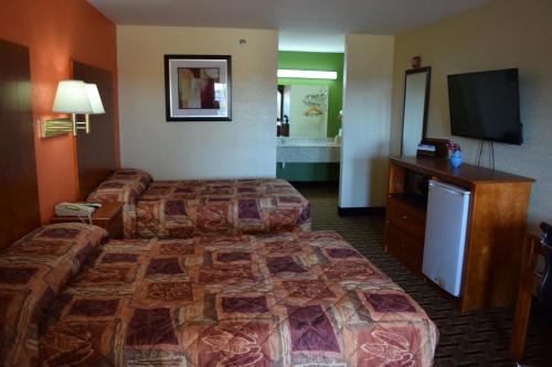 Tempat tidur dalam kamar di Royal Inn & Suites