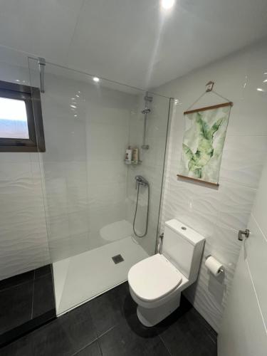 a white bathroom with a shower and a toilet at Diplomatic Salou in Salou