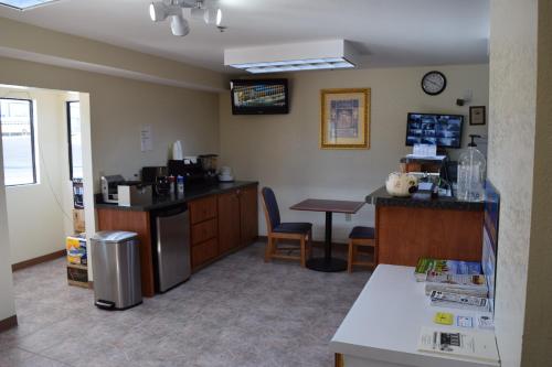 ein Wartezimmer mit einer Theke und einem Tisch in der Unterkunft Royal Inn & Suites in Douglasville