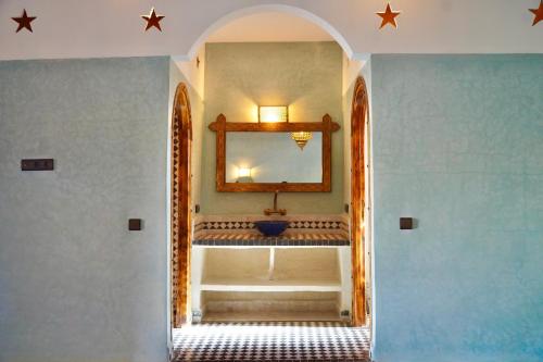 a hallway with a mirror and a sink in a room at Hotel Sunset Palace in Merzouga