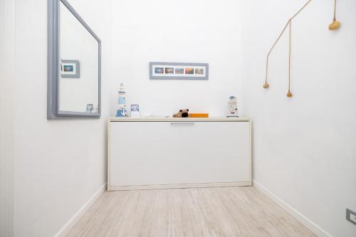 a white room with a large mirror and a white wall at Maison de Pi Sanremo in Sanremo