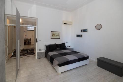a bedroom with a black and white bed and a mirror at Maison de Pi Sanremo in Sanremo