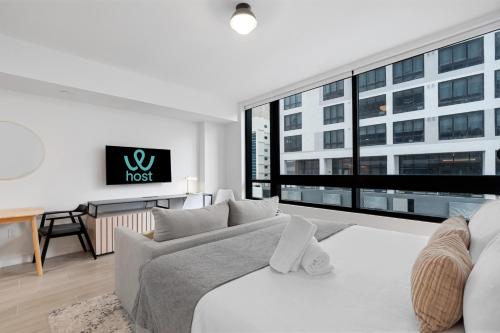 a white living room with a couch and a large window at Stylish Studio in Downtown Location in Miami