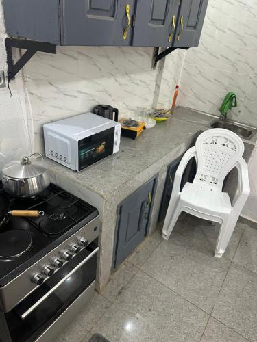 un bancone da cucina con una stufa e una sedia bianca di Sylla hourse's a Conakry