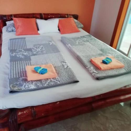 two twin beds with towels on top of them at palm nature lodge in Sanyang