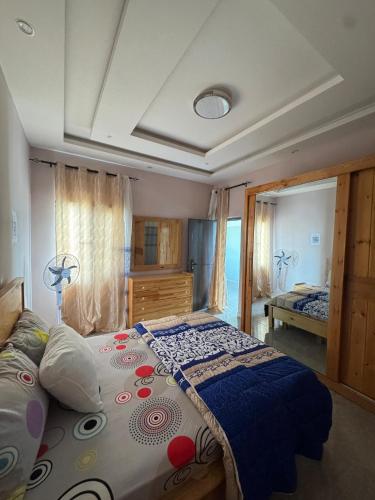 a bedroom with a large bed with a blue blanket at Résidence NDAR CHAMBRES in Saint-Louis