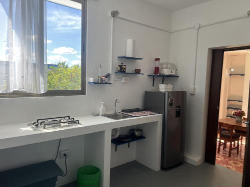 a kitchen with a sink and a refrigerator at Casa Azul en Centro de Mérida in Mérida