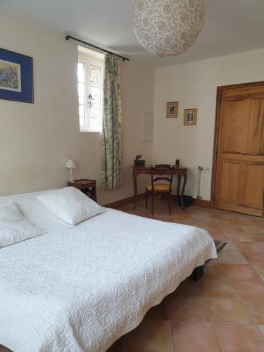 a bedroom with a large bed and a table at Studio, chambre d'hôtes dans mas provençal in Sauzet