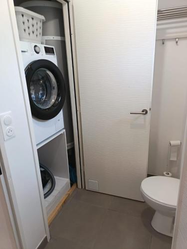 une salle de bains avec lave-linge et toilettes dans l'établissement L'évasion, à Saintes-Maries-de-la-Mer