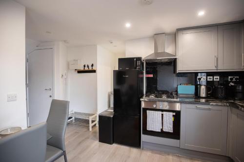 a kitchen with a black refrigerator and a stove at Cozy 2 Bed Flat in Town Centre in Royal Tunbridge Wells