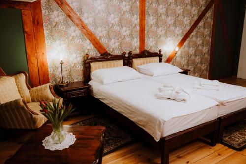 a bedroom with a bed with two towels on it at Dwór Lisewo in Lisewo
