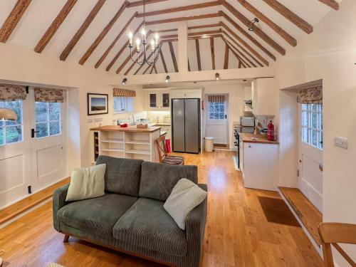 a living room with a couch and a kitchen at Leacon Hall Lodge in Orlestone