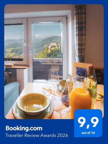 a table with wine glasses and a window with a view at Haus Biechl mit Blick auf die Burg Hohenwerfen in Pfarrwerfen