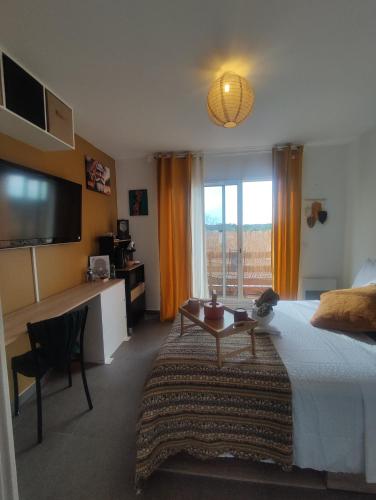 a hotel room with a bed and a table and a television at O'me Wally in Galargues