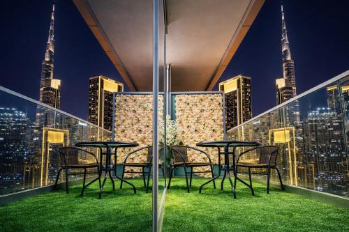 a table and chairs on a balcony with a city skyline at 2BR Burj Khalifa and Sea View Apartments in Paramount Hotel Midtown in Dubai