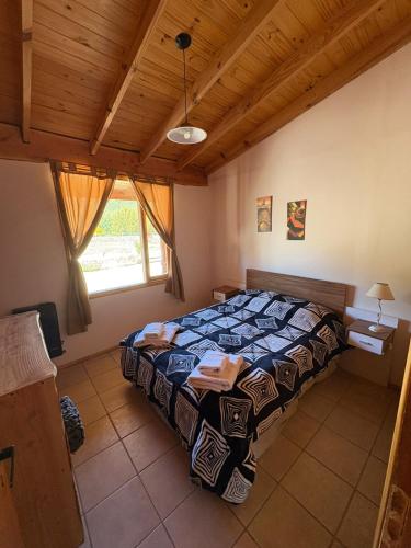 a bedroom with a bed and a wooden ceiling at Complejo Cabañas Ganesh in Lago Meliquina