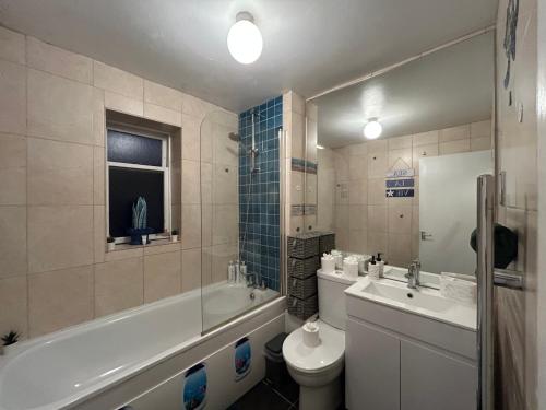 a bathroom with a tub and a toilet and a sink at Brighton Central Home with free parking in Brighton & Hove