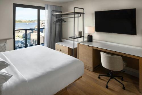 a hotel room with a bed and a desk and a television at Delta Hotels by Marriott Halifax Downtown in Halifax