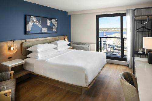 a bedroom with a large white bed and a large window at Delta Hotels by Marriott Halifax Downtown in Halifax