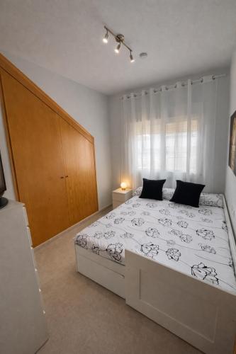 a bedroom with a large bed and a wooden cabinet at Apartamento Turístico Les Dunes in Els Muntells