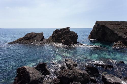 a group of rocks in the water near the ocean at Green&Houses in Ponta Delgada