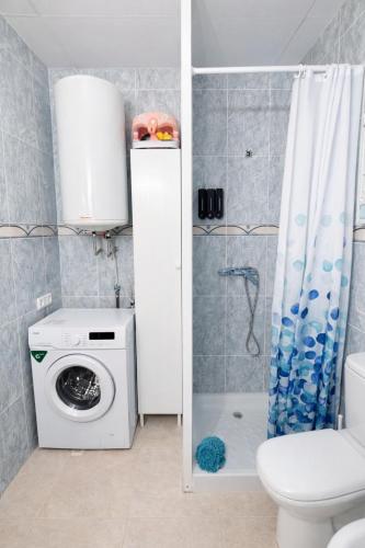 a bathroom with a shower and a washing machine at Apartamento Turístico Les Dunes in Els Muntells