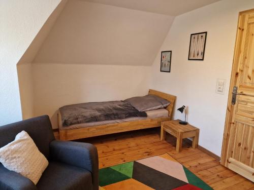 a bedroom with a bed and a couch and a table at Rettiner Sandbank in Neustadt in Holstein