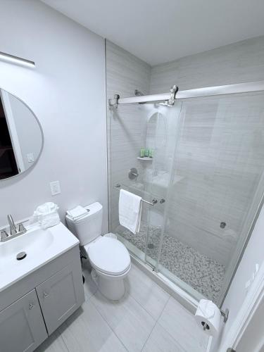 a white bathroom with a shower and a toilet at The Tel Ft Lauderdale in Fort Lauderdale