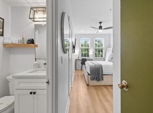 a bedroom with a bed and a bathroom with a sink at Tropicals of Palm Beach in Palm Beach