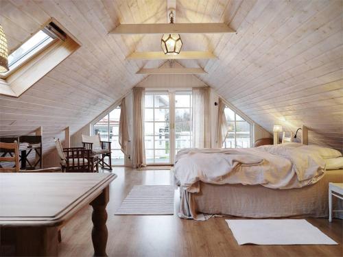 a bedroom with a large bed in a wooden ceiling at Apartment at Prästtorp in Brastad