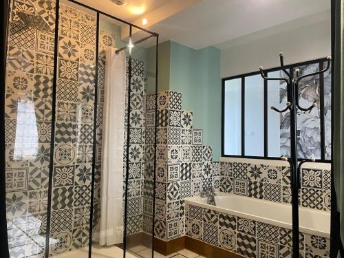 a bathroom with a shower and a tub and a sink at Le Cosy 8km du futuroscope in Beaumont
