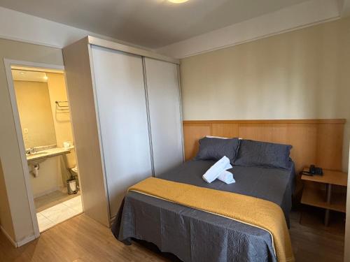 a bedroom with a bed with two towels on it at Hotel Flat Biena Parque Ibirapuera 810 incluso estacionamento in São Paulo