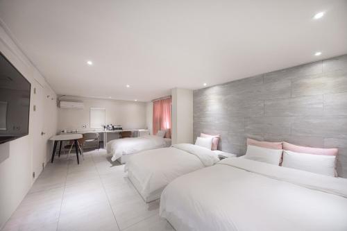 a hotel room with two beds and a kitchen at MoMo Juice Busan Haeundae in Busan