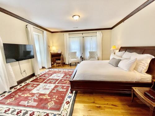 a bedroom with a bed and a television and a desk at Dartmouth House Inn in Rochester