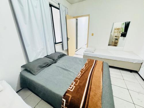 a bedroom with two beds and a mirror at ap 2 quartos com ar e garagem bairro derby in Sobral