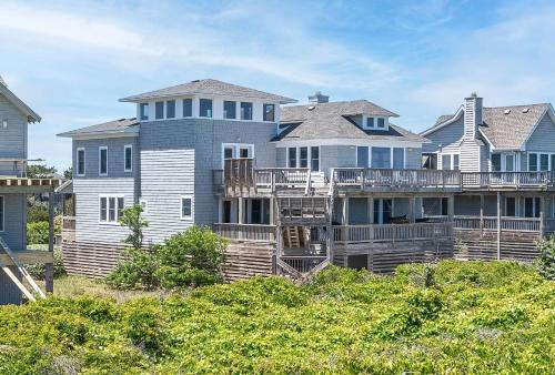 a large house on a beach with houses at Run-A-Way Bay - Duck, Sanderling, Oceanfront, Ocean View, Hot Tub, Community Pool, Tennis in Duck