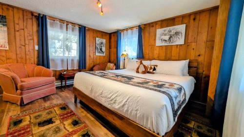 a bedroom with a bed and a chair at Alpen Way Chalet Mountain Lodge in Evergreen