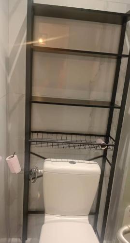 a bathroom with a toilet with a shelf above it at Aurora in Montauroux