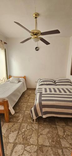 a bedroom with a ceiling fan and a bed at Lo de Nilda in Playa Unión