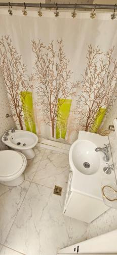 a white bathroom with a toilet and a sink at Lo de Nilda in Playa Unión