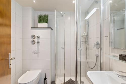 a bathroom with a shower and a toilet and a sink at Gaestehaus Florian - Ferienwohnungen in Grainau
