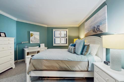 a bedroom with a bed with blue walls and a desk at OIB74 Kat Cove 2 in Ocean Isle Beach