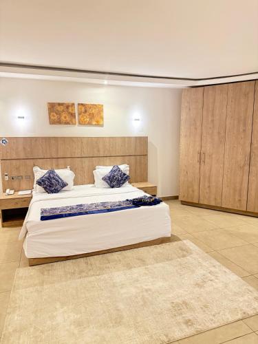 a large bedroom with a large bed with blue pillows at SAAFI Boutique Hotel in Abuja