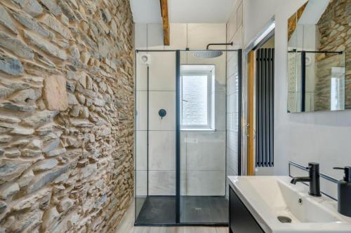a bathroom with a glass shower and a stone wall at 1 Bed in Tebay oc-m29886 in Tebay