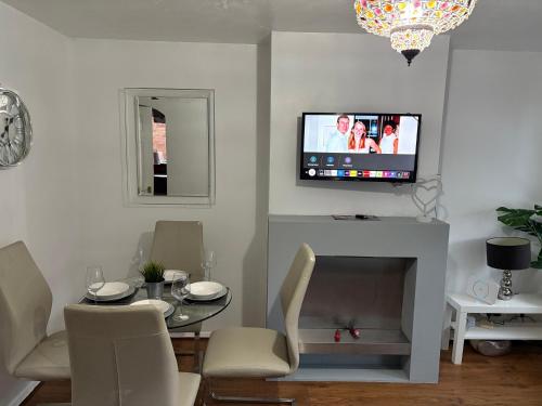 a living room with a table and a tv on the wall at FilmonHomes in Oldbury