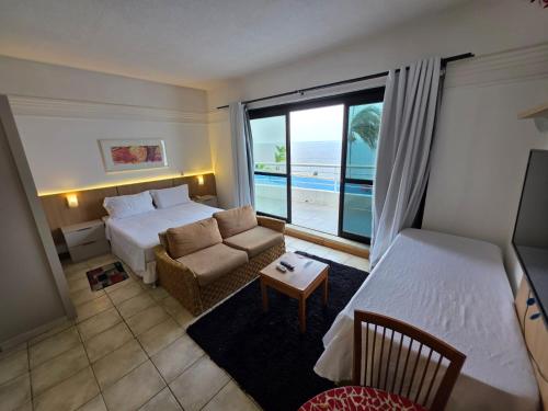 a hotel room with a bed and a couch at Tropical Executive Flat Vista Maravilhosa do Rio in Manaus