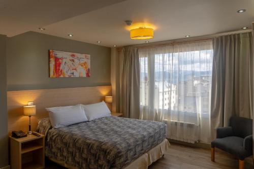 a hotel room with a bed and a large window at Monte Claro in San Carlos de Bariloche