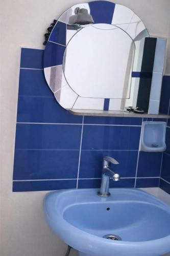a blue tiled bathroom with a sink and a mirror at Mostafa Gest House in Asyut