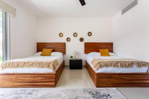two beds in a bedroom with white walls at MAREAZUL Beachfront Apartment 2BR Private Pool Casa Áncora in Playa del Carmen