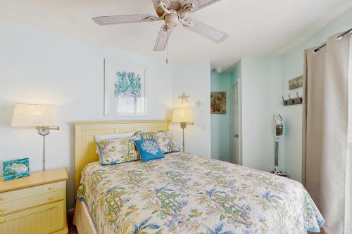 a bedroom with a bed and a ceiling fan at OIB88 PierSide Paradise in Ocean Isle Beach